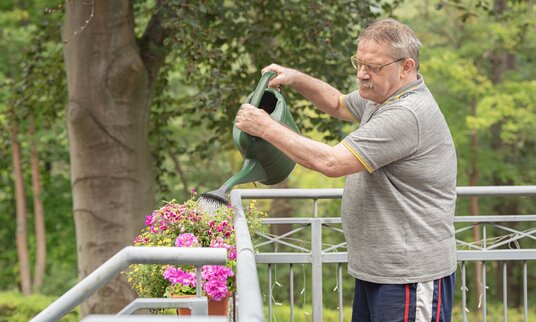 Bewohner beim Blumengießen